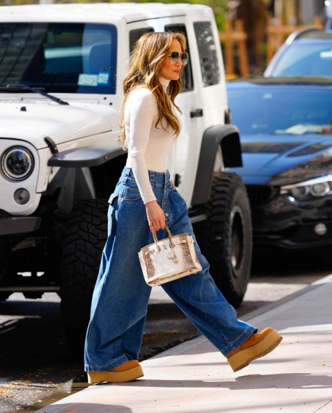 Jennifer Lopez wore her go-to barrel-leg jeans again. See her spring-ready cozy look, here.