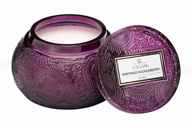 The Voluspa Santiago Huckleberry candle contains notes of huckleberry, vanilla, and crushed sugar cane, comes in an embossed glass jar, and has a burn time of 100 hours. You can get it on Amazon for $23.
