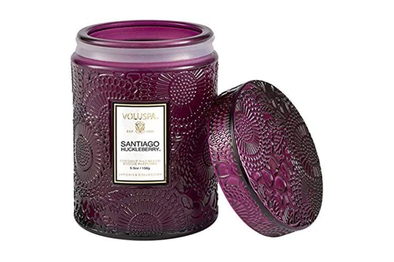 The Voluspa Santiago Huckleberry candle contains notes of huckleberry, vanilla, and crushed sugar cane, comes in an embossed glass jar, and has a burn time of 100 hours. You can get it on Amazon for $23.