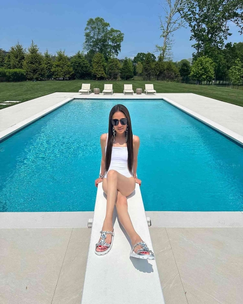 Vera Wang posted an Instagram photo wearing a white one-piece swimsuit and silver slingback sandals by the pool. Shop similar metallic summer sandals and white bathing suits from Amazon, Nordstrom, Zappos, and more.