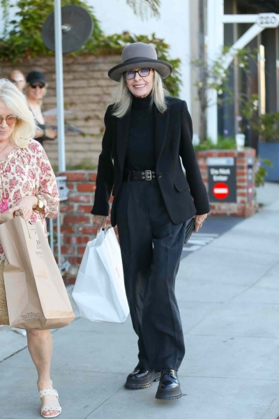 Look of the Day for August 21, 2024 features Diane Keaton in an all-black outfit, including a black top, blazer, billowy black trousers, and chunky combat boots.