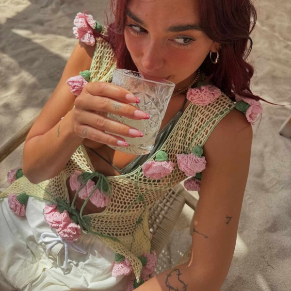 Singer Dua Lipa's latest Instagram post shows her wearing silky black boxer shirts and a draped black halter top. See her look, here.