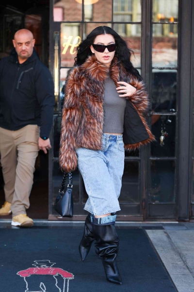 Look of the Day for November 13, 2024 features Charli XCX in a bold winter outfit, including denim Bermuda shorts, slouchy leather boots, fuzzy coat, and the famous Aupen Nirvana bag.